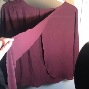 Maroon blouse with open back and buttoned sleeves.